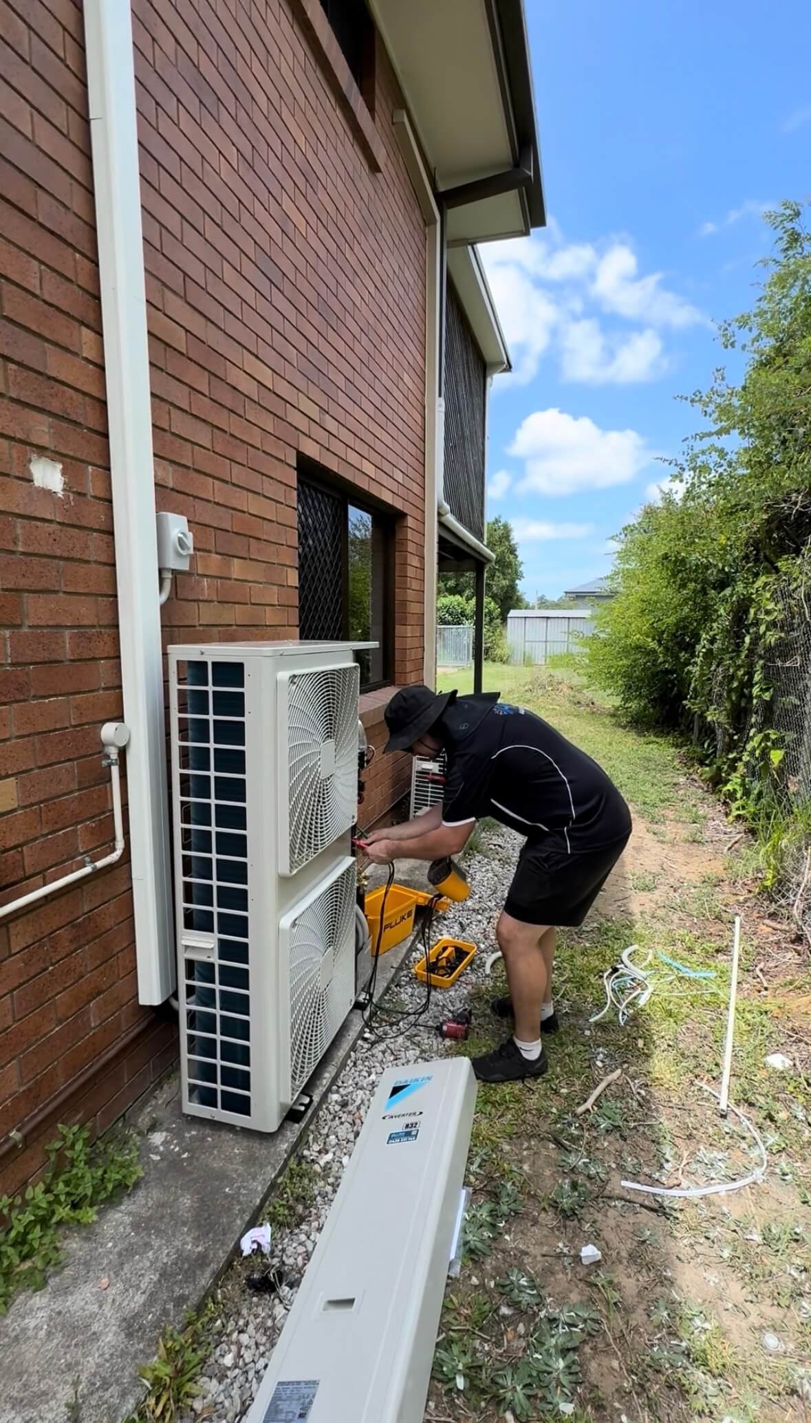 Technician carrying out electrical testing after installation of a new ducted air conditioner.