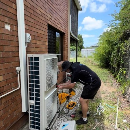 Technician carrying out electrical testing after installation of a new ducted air conditioner.